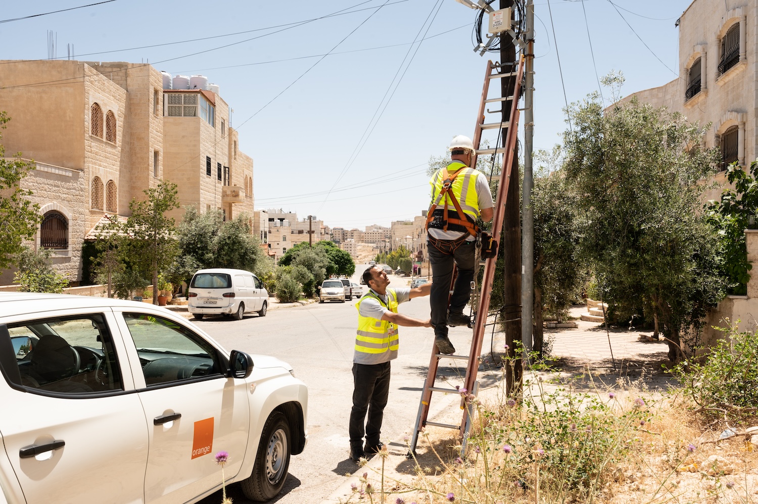 Deux techniciens d'orange sont en train de réparer une connexion en pleine rue