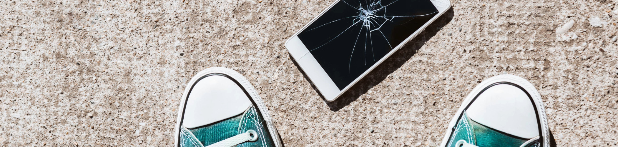 Mobile cassé au sol aux pieds d'une personne