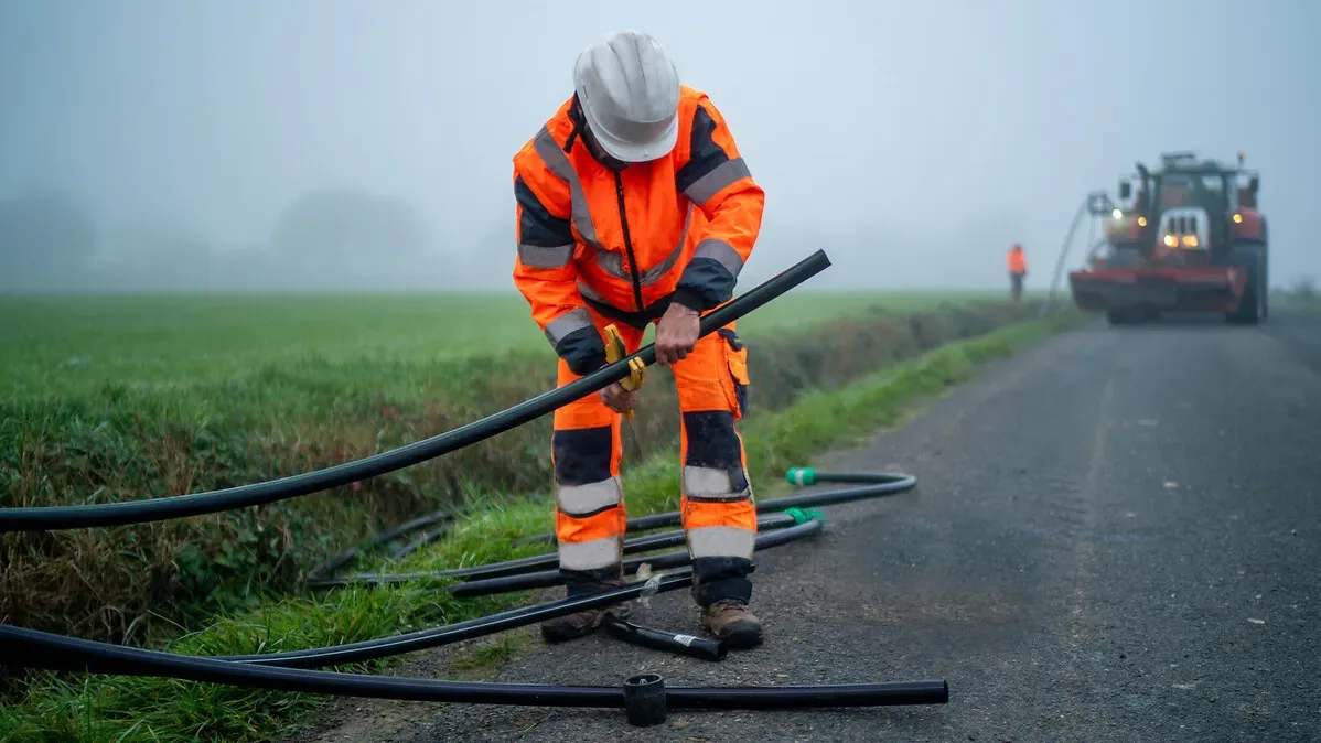 Technicien Orange en train de sectionner un câble fibre à la campagne