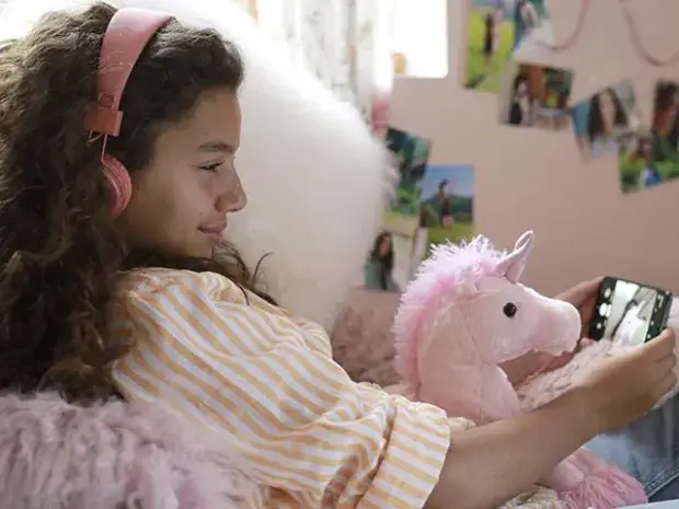 une jeune fille se photographie avec son doudou