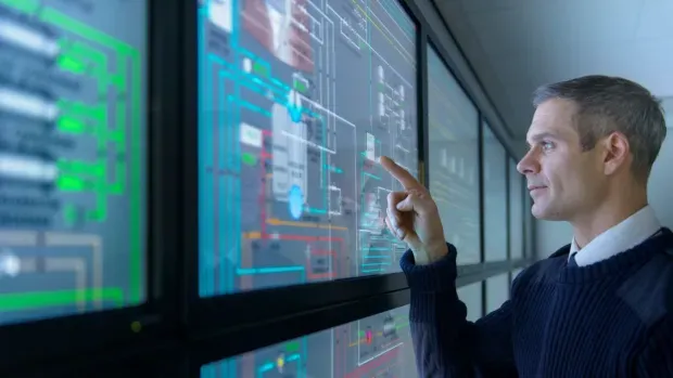 Homme regardant des données sur des écrans tactiles