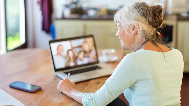 Une dame consultant son ordinateur au sein de son foyer