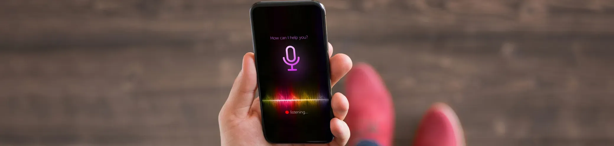 Un homme consulte son mobile via une commande vocale