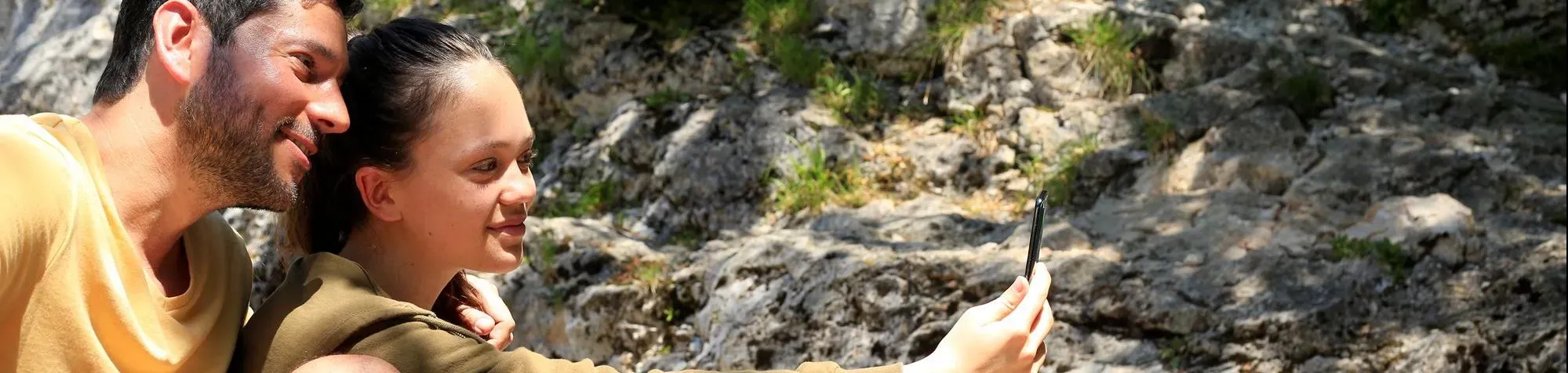 A father and his daughter do a selfie in the mountains