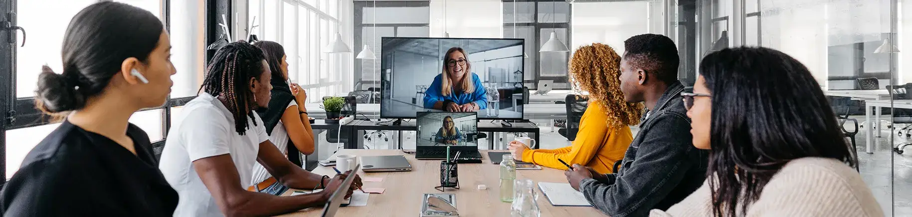 Photo de personnes autour d'une table en vidéoconférence