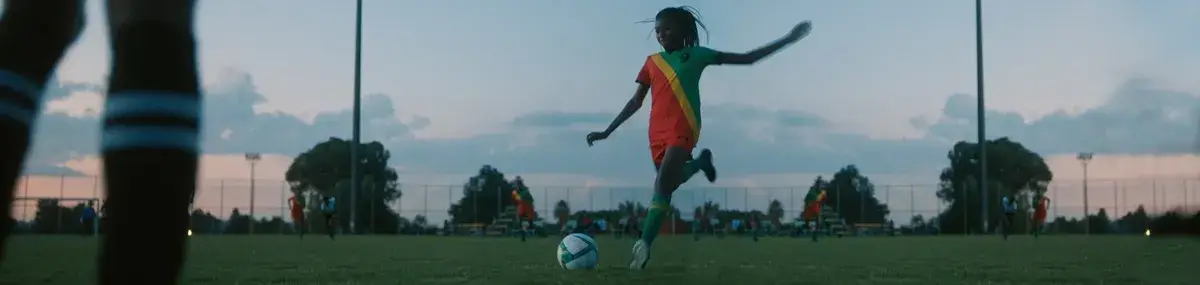 une jeune femme africaine joue au football