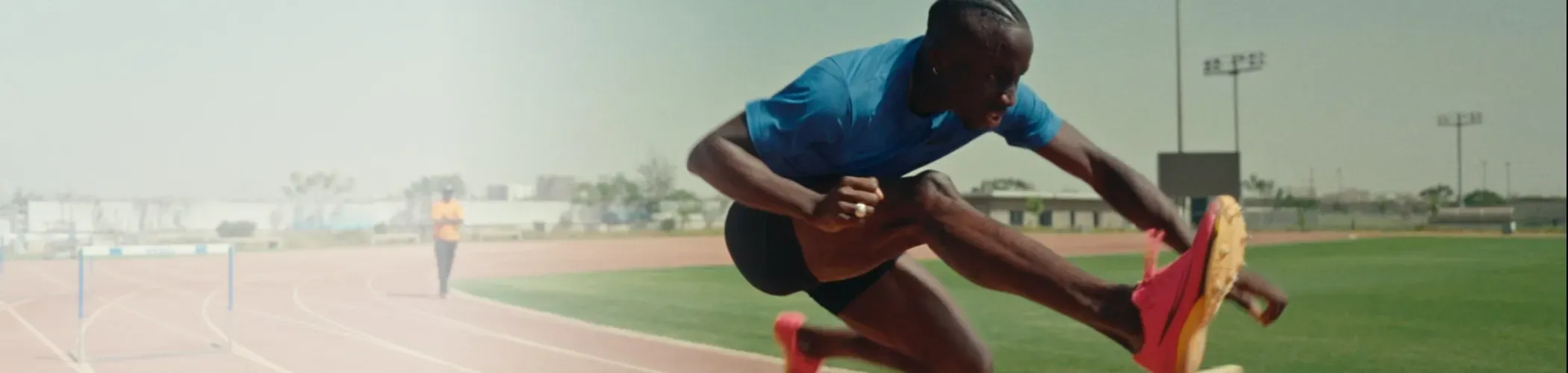 Louis François Mendy saute une haie sur un terrian d'athlétisme au Sénégal