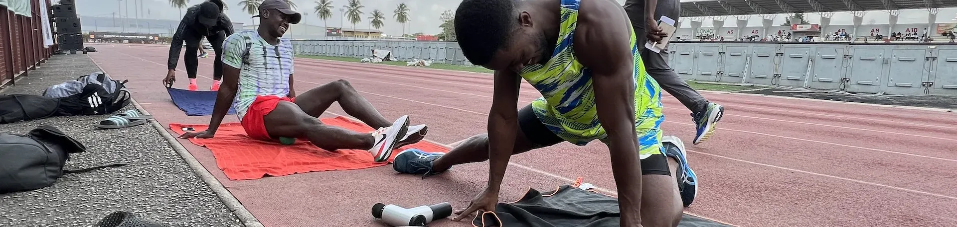 Photo d'Arthur Cissé qui s'échauffesur un terrain de course avec d'autres athlètes