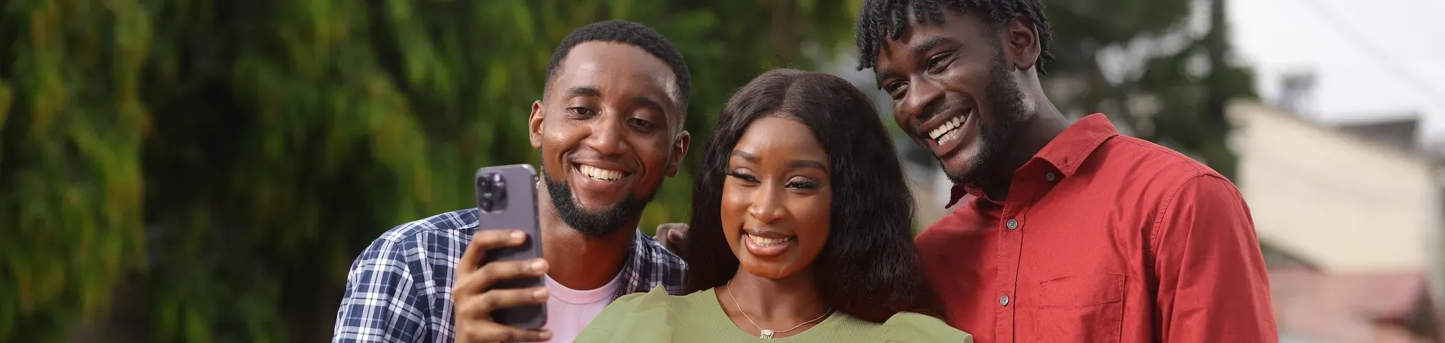 Photo de trois personnes regardant un téléphone