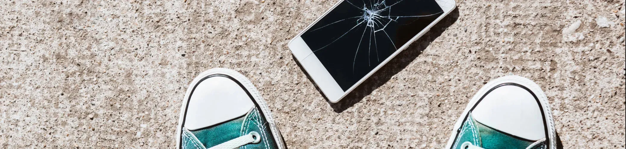 Mobile cassé au sol aux pieds d'une personne