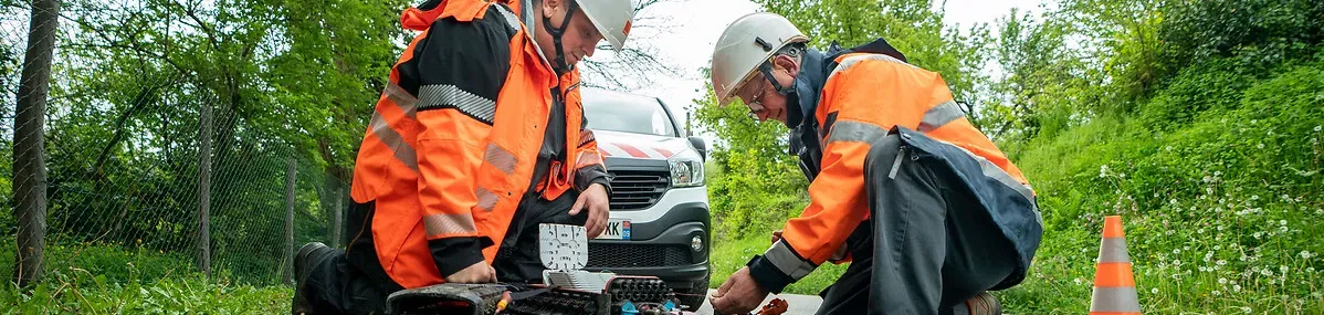 2 techniens Orange interviennent en extérieur sur une route de campagne