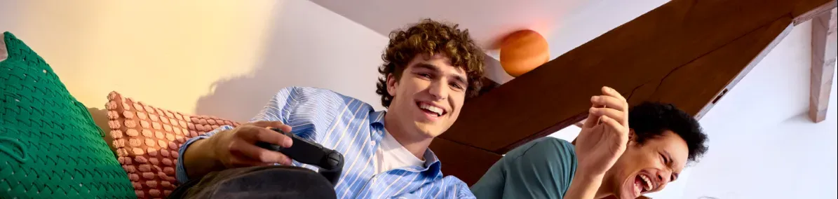 Photo d'un homme jouant à la console avec 2 amis