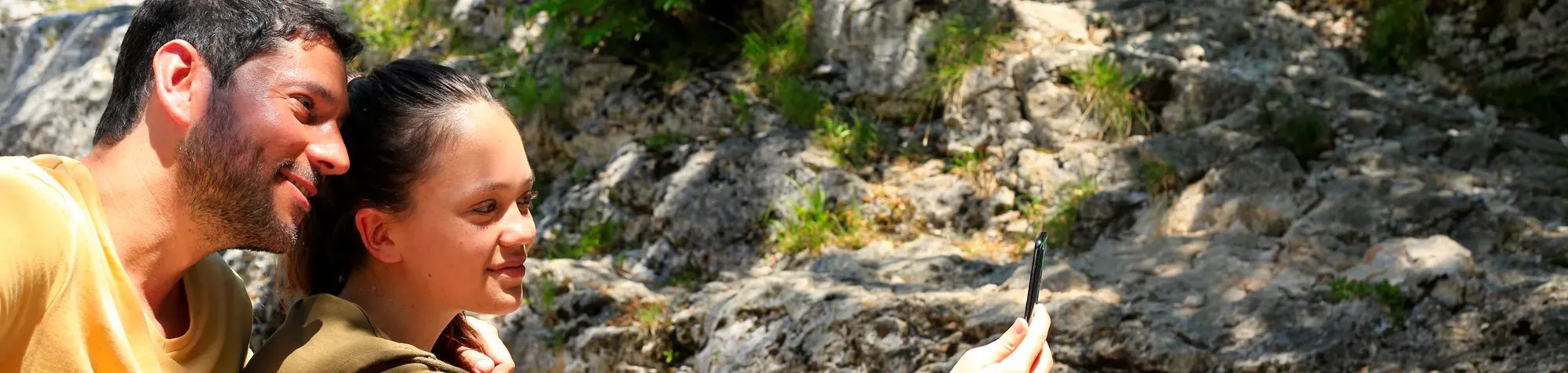 Un père et sa fille font un selfie lors d'une ballade en montagne