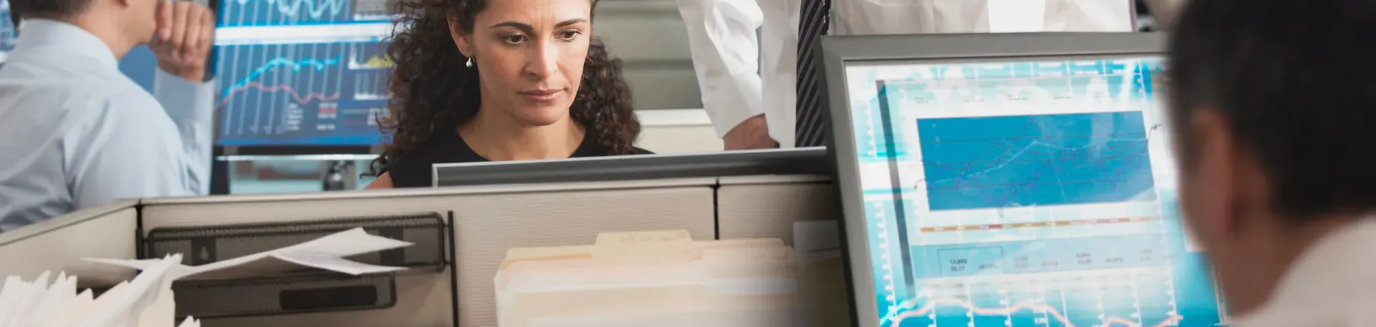 Salle de marché avec des hommes et femme derrières des ordinateurs