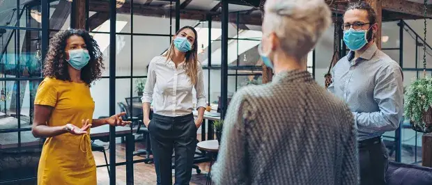 photo 4 collaborateurs masqués dans un bureau