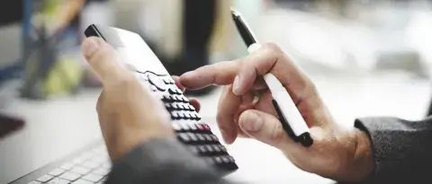 homme tapant sur une calculatrice 