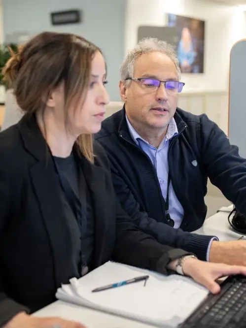 2 salariés échangent devant un écran d'ordinateur