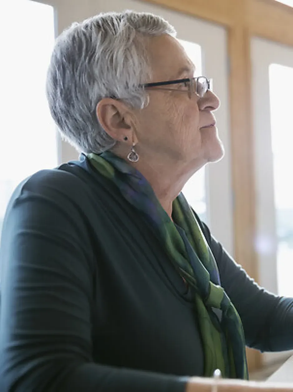 Femme âgée avec des lunettes utilisant une tablette lors d'un atelier