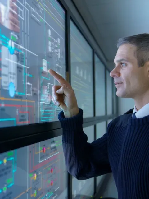 Homme regardant des données sur des écrans tactiles