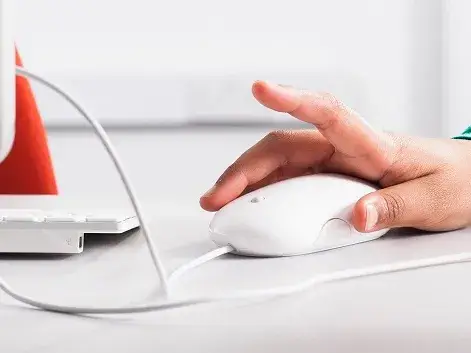 une main sur la souri d'un ordinateur