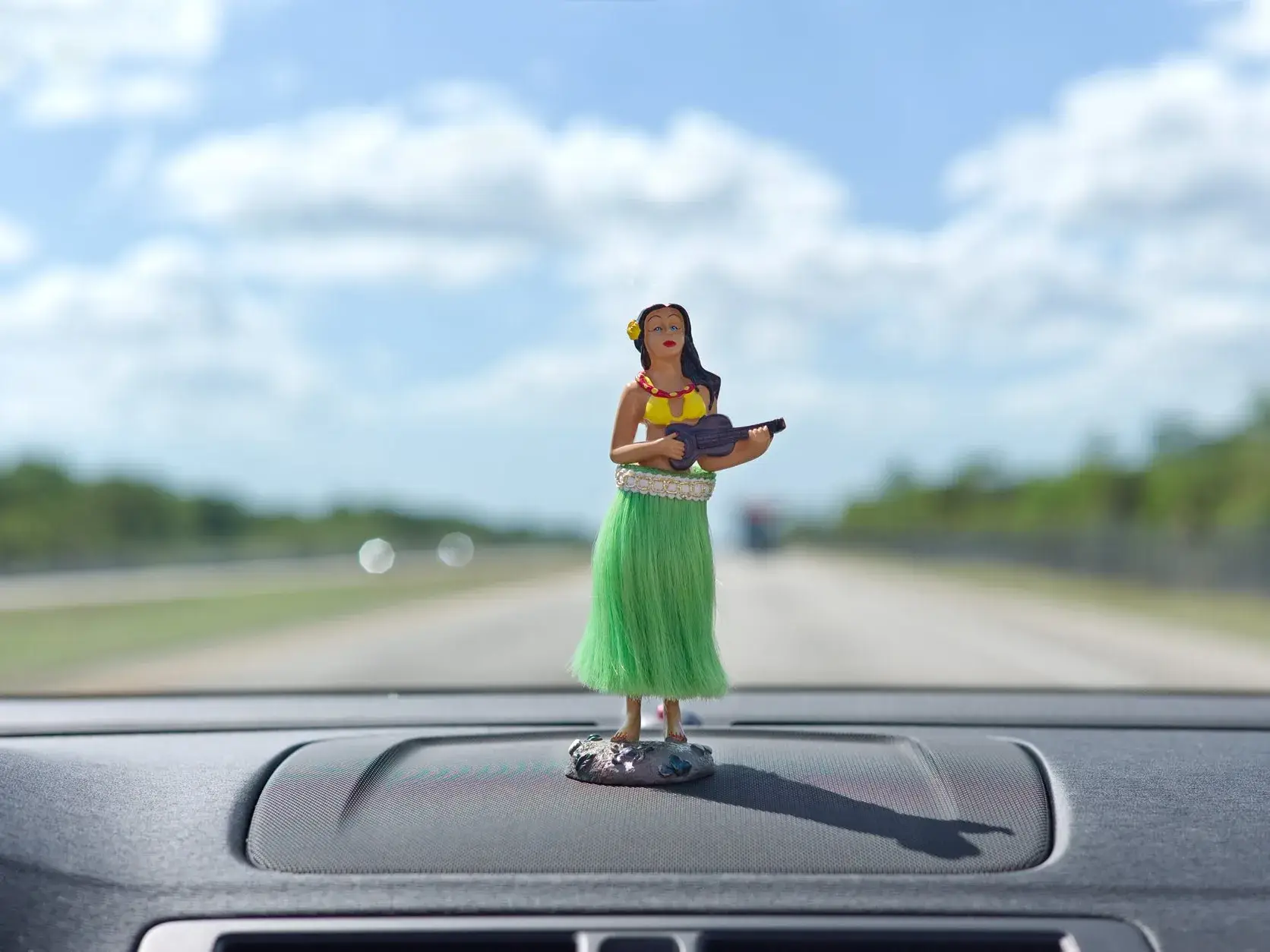 Statuette de vahiné sur le tableau de bord d'une voiture