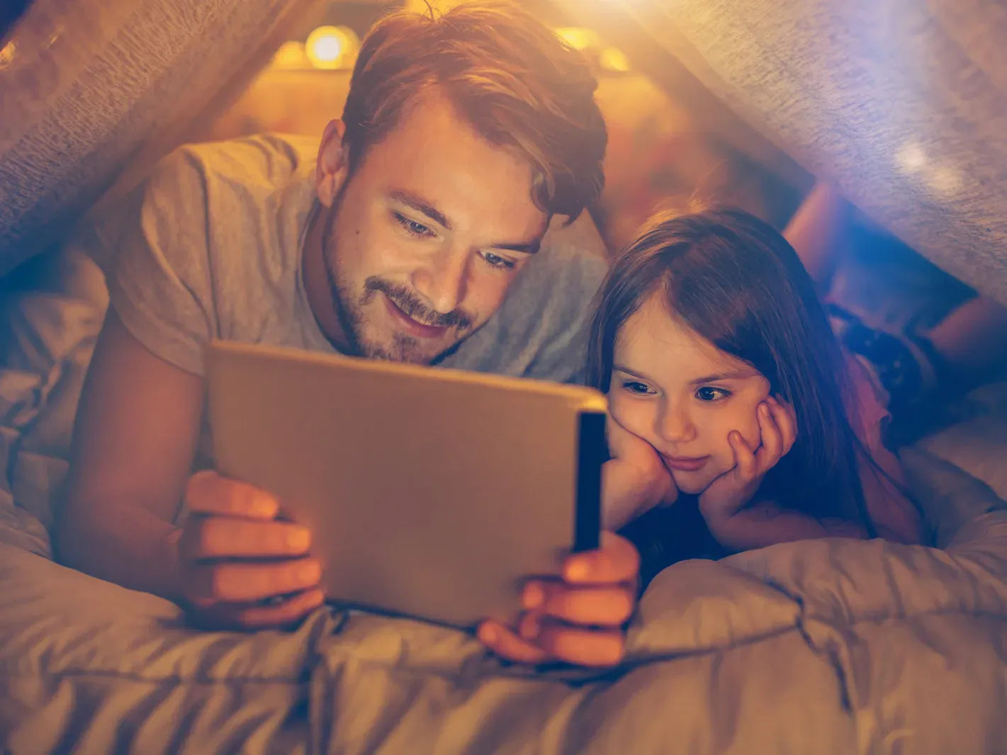 Father with daughter consulting a tablet