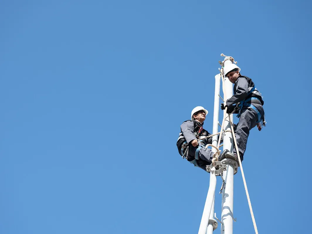 deux techniciens en intervention sur une antenne de télécommunication