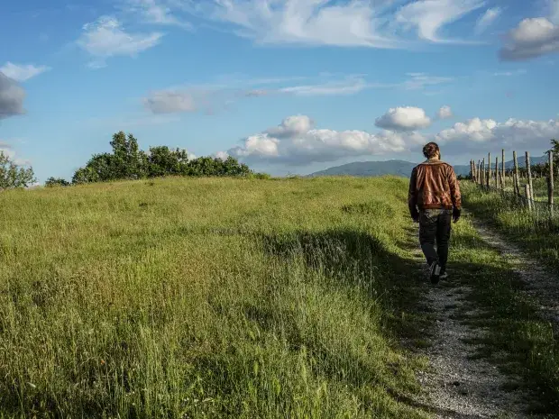 Un homme marche sur un chemin de campagne