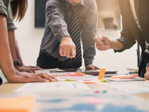 Une équipe travaillant sur un projet, des post-it et des documents sur une table