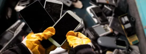 2 mains gantés récupèrent 3mobiles usagés dans une benne de recyclage
